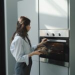 A woman opening her modern in-built oven